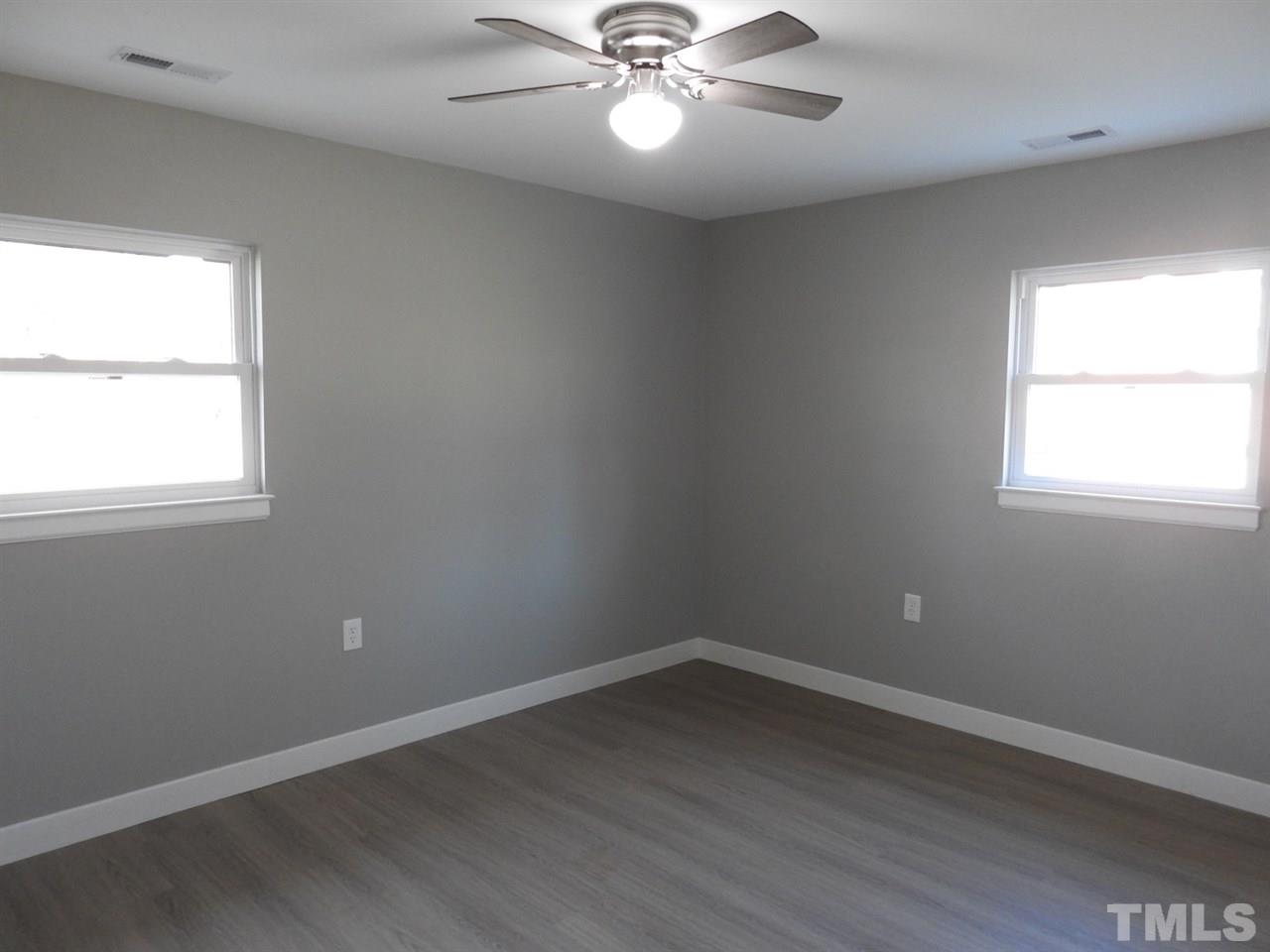 41 Peace Street Roxboro, NC 27573 - Photo 19 of 20 an empty room with wooden floor windows and fan