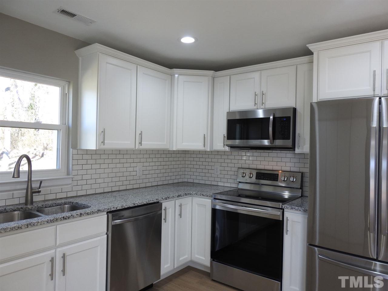 41 Peace Street Roxboro, NC 27573 - Photo 6 of 20 a kitchen with granite countertop a sink stainless steel appliances and cabinets