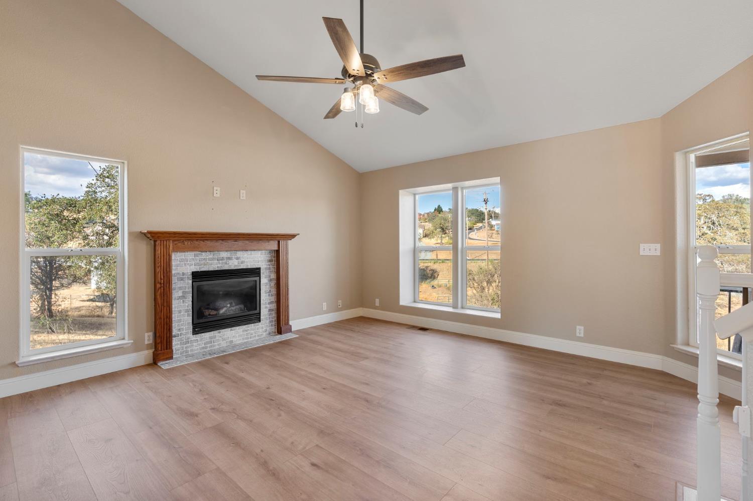 4068 Little John Road Copperopolis, CA 95228 - Photo 13 of 46 an empty room with windows fireplace and wooden floor