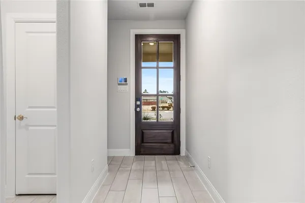 an empty room with wooden floor cabinet and windows