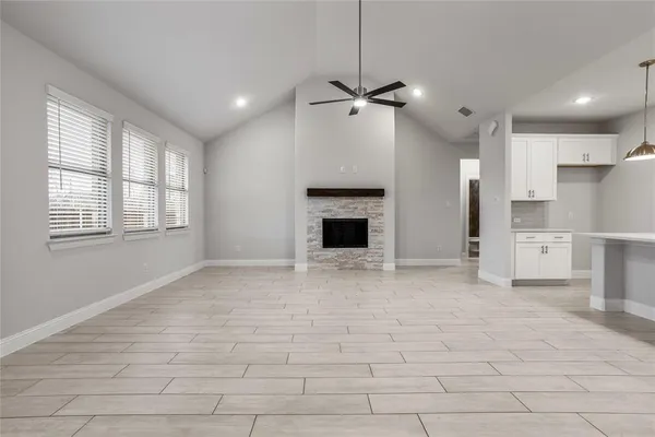 a view of empty room with a fireplace and window