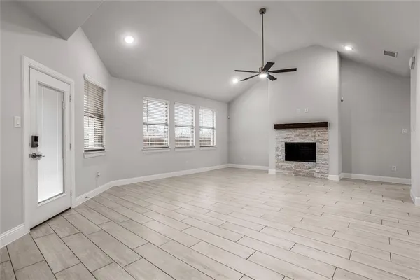 an empty room with windows and fireplace