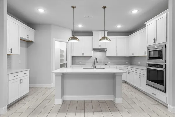 a large kitchen with kitchen island a sink stainless steel appliances and cabinets