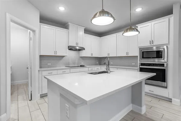 a kitchen with stainless steel appliances a sink a stove a microwave and cabinets