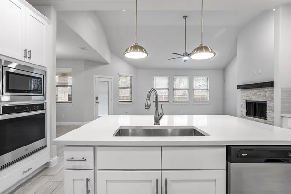 a kitchen with a center island a stove cabinets and stainless steel appliances
