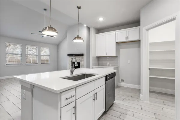 a kitchen with kitchen island a sink stainless steel appliances and a chandelier