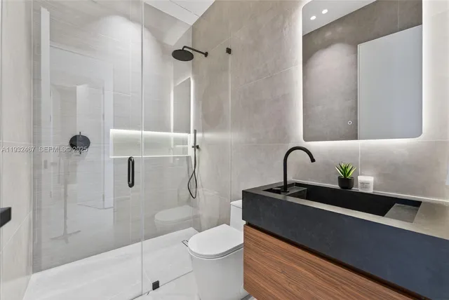 a bathroom with a granite countertop sink a toilet and shower