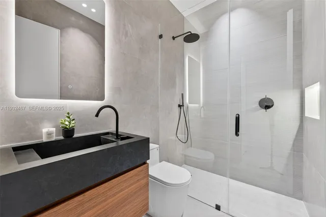 a bathroom with a sink a toilet and shower