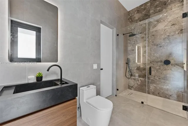 a bathroom with a double vanity sink toilet and shower