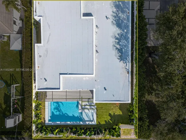 an aerial view of residential houses with outdoor space and swimming pool