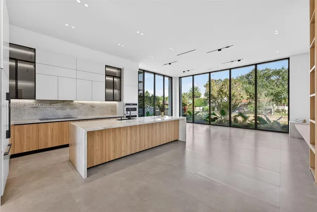a large kitchen with kitchen island granite countertop a large window