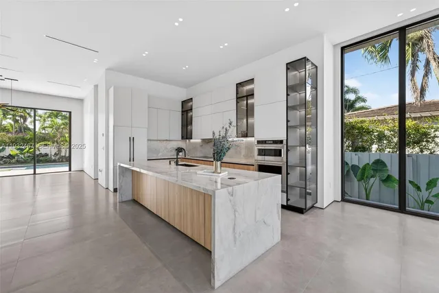 a large white kitchen with a large window