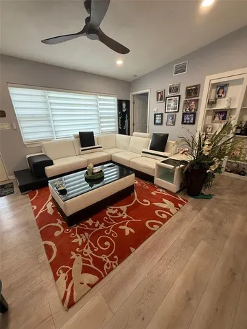 a living room with furniture flat screen tv and a window
