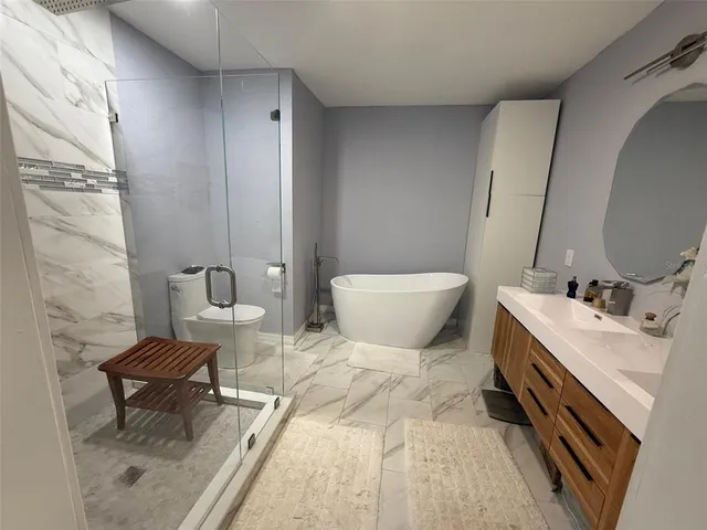 a spacious bathroom with a double vanity sink a mirror and a toilet