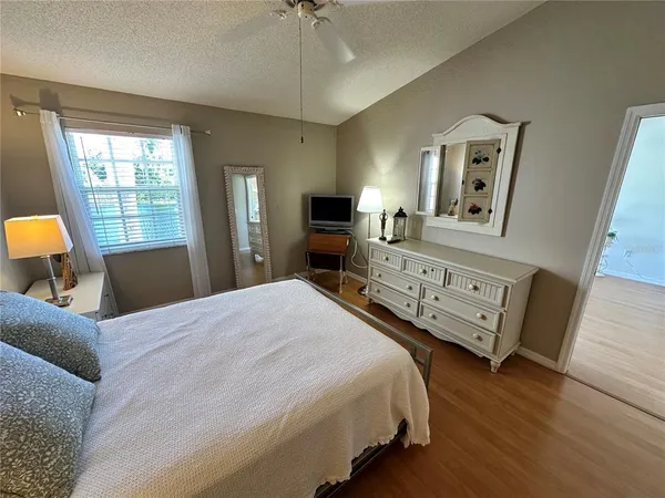 a bedroom with a bed and wooden floor