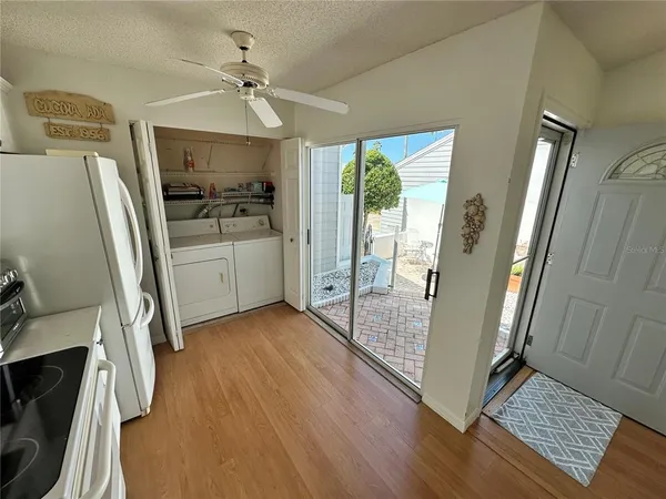 a view of entryway with kitchen and wooden floor