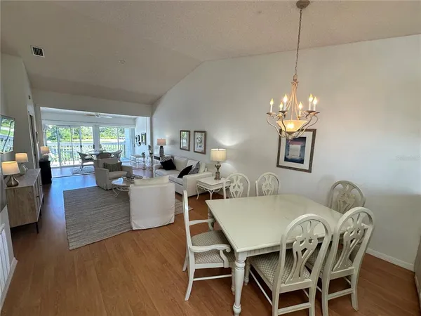 a view of a dining room with furniture a chandelier and wooden floor