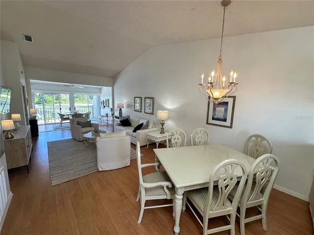 a view of a dining room with furniture a chandelier and wooden floor