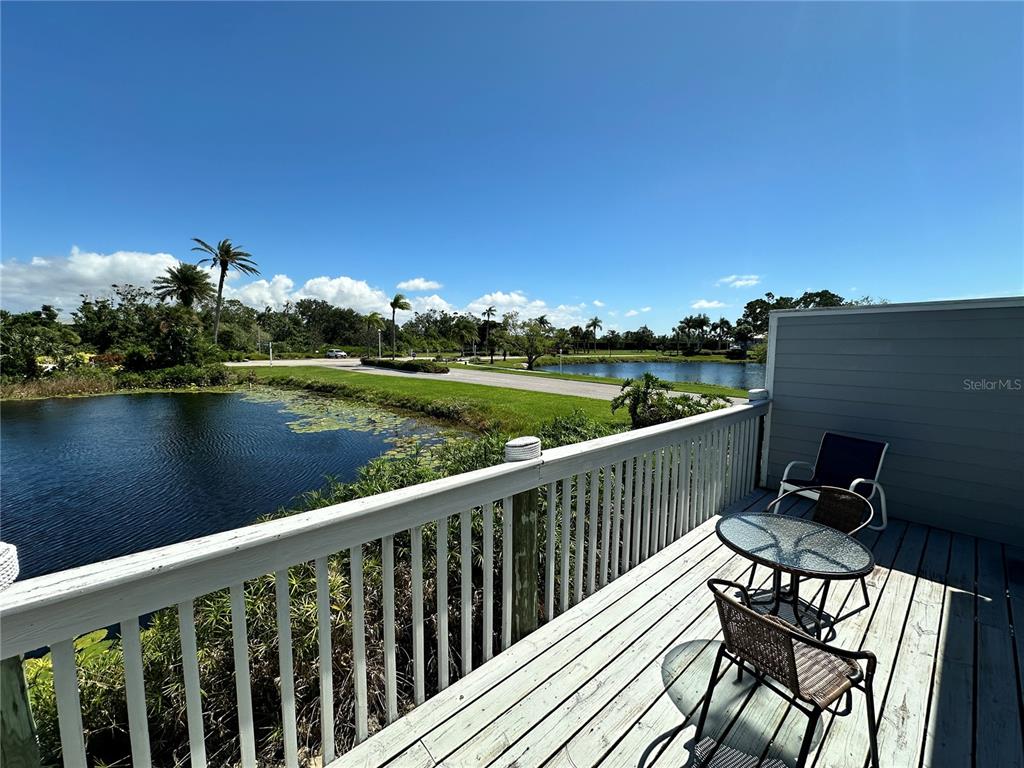 517 Woodstork Circle Bradenton, FL 34209 - Photo 10 of 34 a view of a balcony with wooden chairs and floor to ceiling window