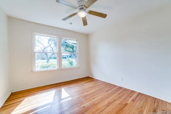 wooden floor in an empty room with a window