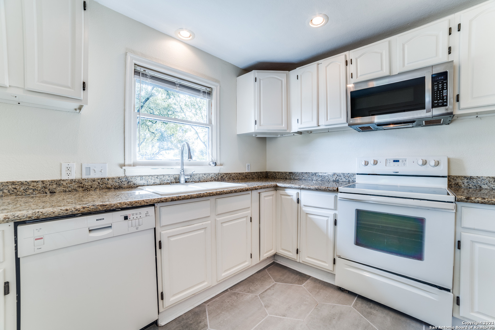 1149 Garraty Road San Antonio, TX 78209 - Photo 8 of 25 a kitchen with granite countertop white cabinets stainless steel appliances and a window