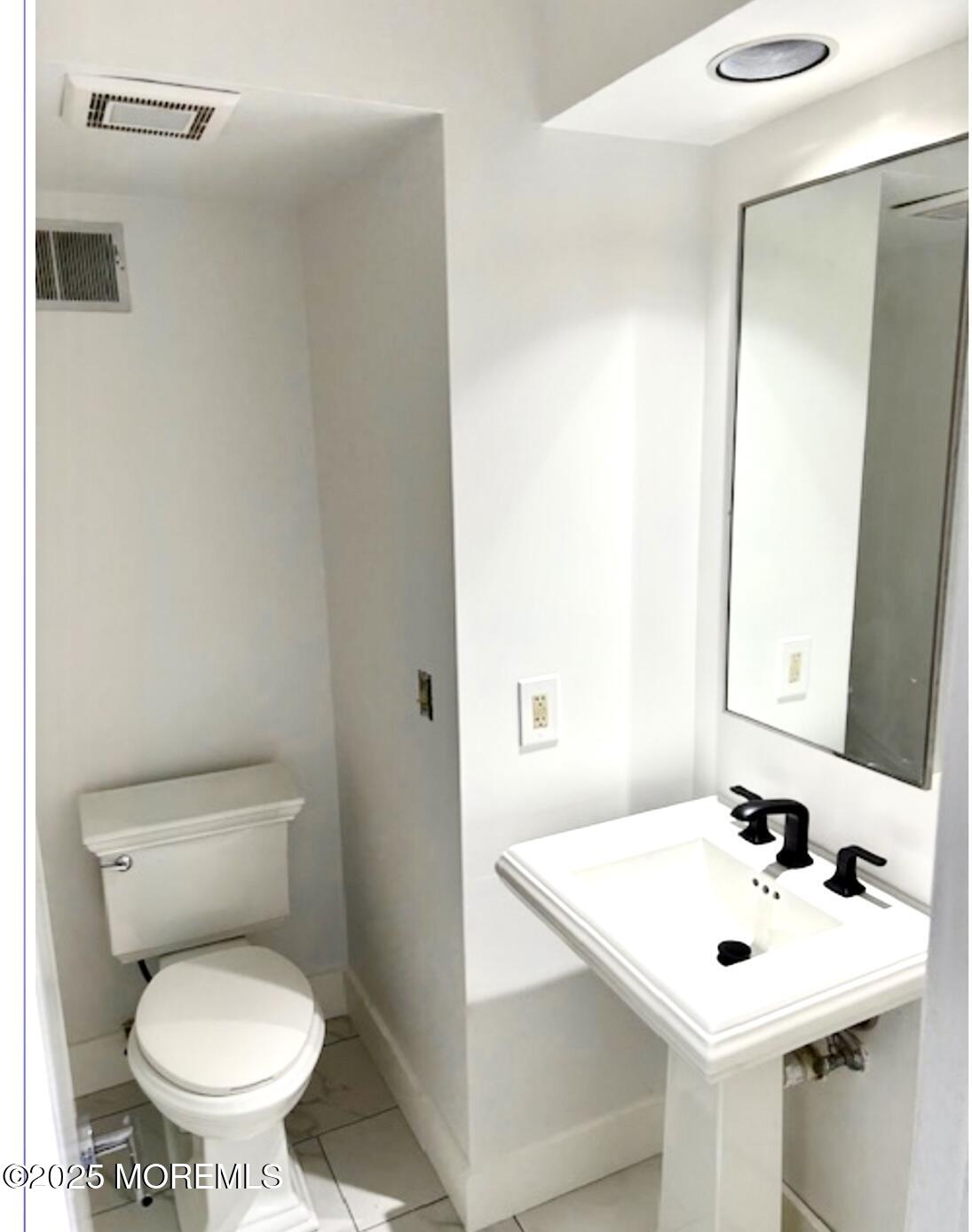 5 Sea Breeze Court Long Branch, NJ 07740 - Photo 16 of 28 a white toilet sitting next to a bathroom sink