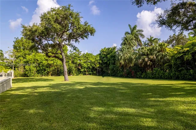 a view of a swimming pool with a patio and a yard