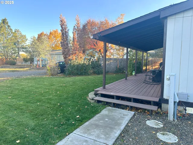 a view of a backyard with table and chairs under an umbrella