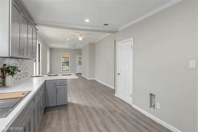 a large kitchen with stainless steel appliances granite countertop a lot of counter space and wooden floors