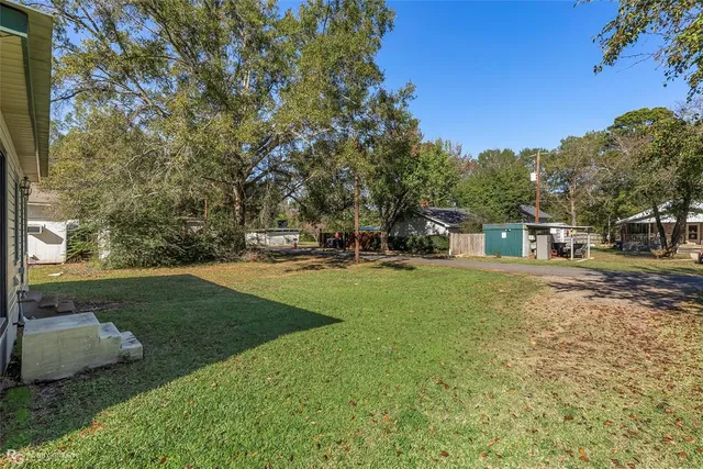 a view of a house with backyard and trees