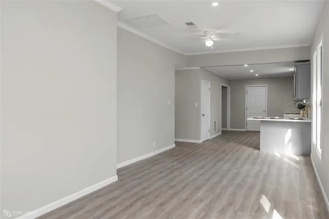 a view of an empty room with a window and wooden floor