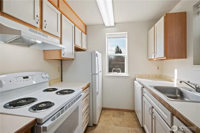 a kitchen that has a sink a stove and a refrigerator