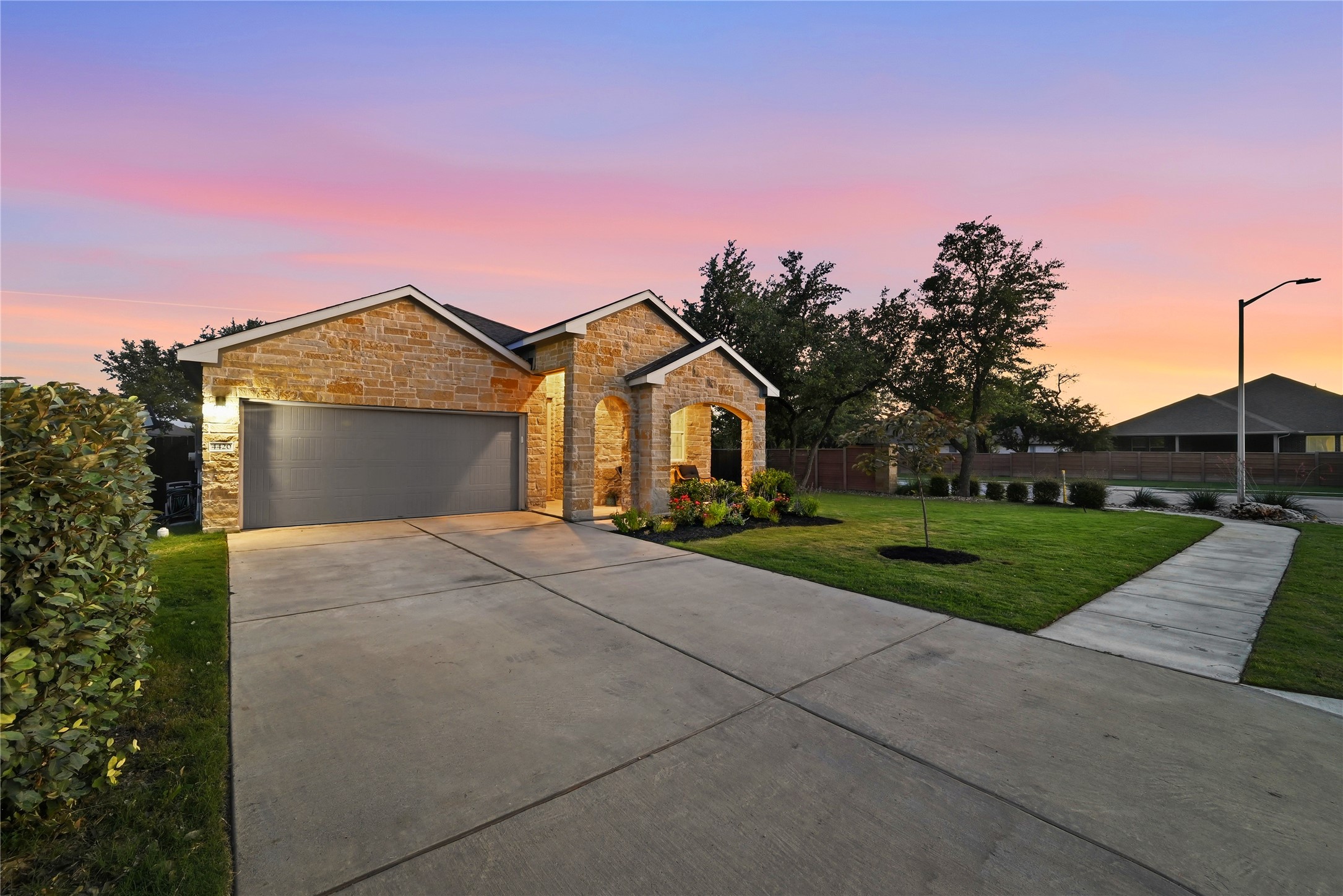 4420 Ingram Road Georgetown, TX 78628 - Photo 4 of 40 An inviting stone facade under a vibrant sunset sky welcomes you home.