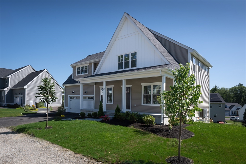 145 Mantell Road Uxbridge, MA 01569 - Photo 5 of 13 a front view of a house with a yard and trees