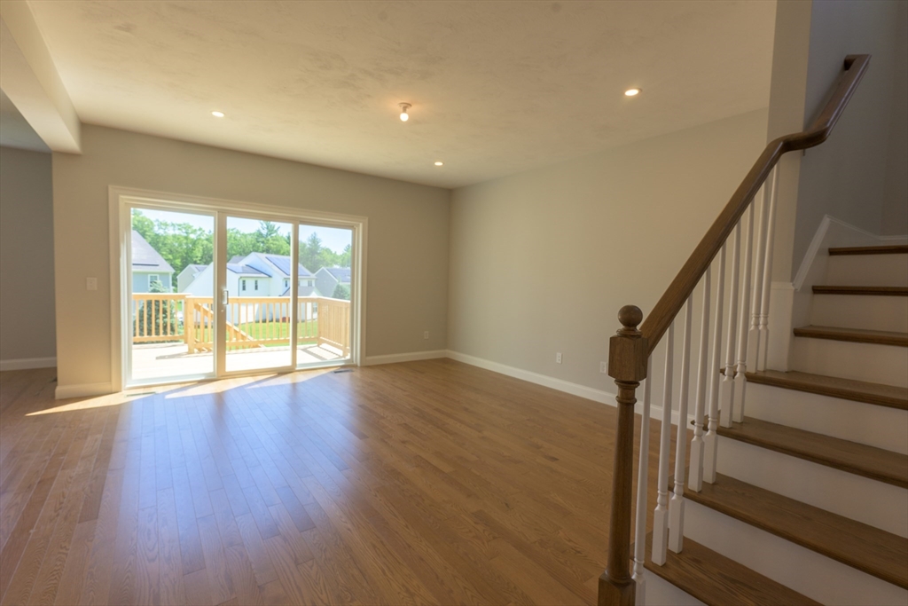 145 Mantell Road Uxbridge, MA 01569 - Photo 7 of 13 a view of an empty room with wooden floor and fan