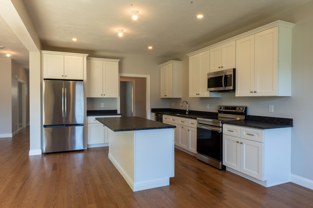 145 Mantell Road Uxbridge, MA 01569 - Photo 8 of 13 a kitchen with kitchen island a refrigerator sink and wooden floor