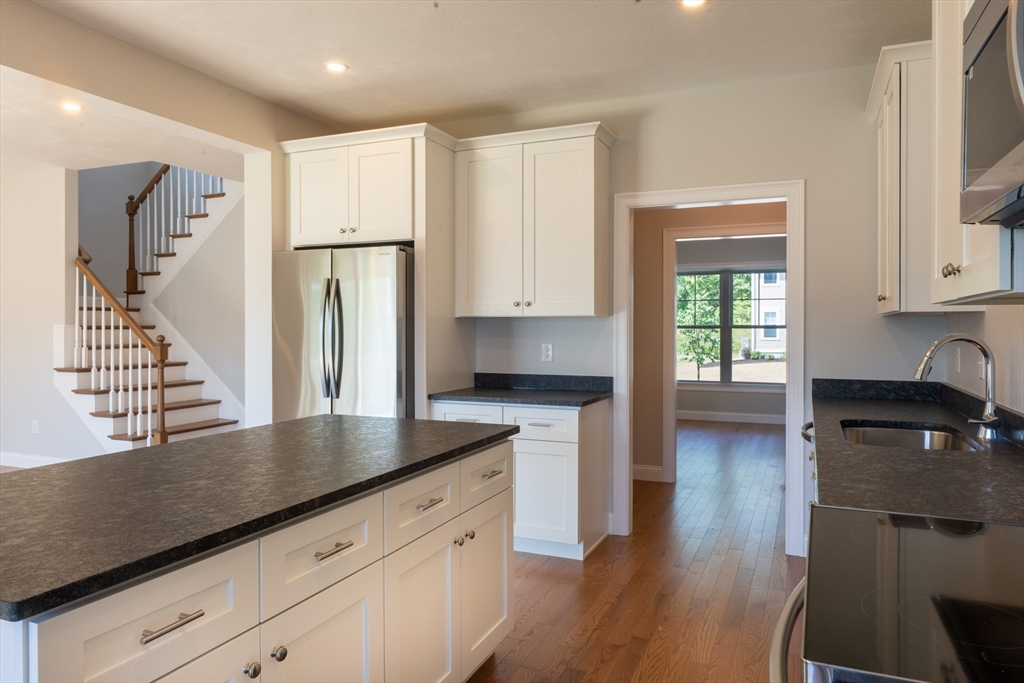 145 Mantell Road Uxbridge, MA 01569 - Photo 9 of 13 a kitchen with granite countertop a refrigerator and a stove top oven