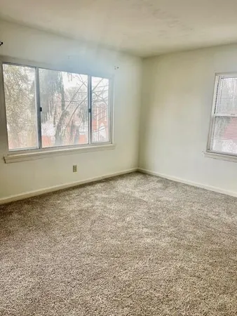 an empty room with a window and a fan