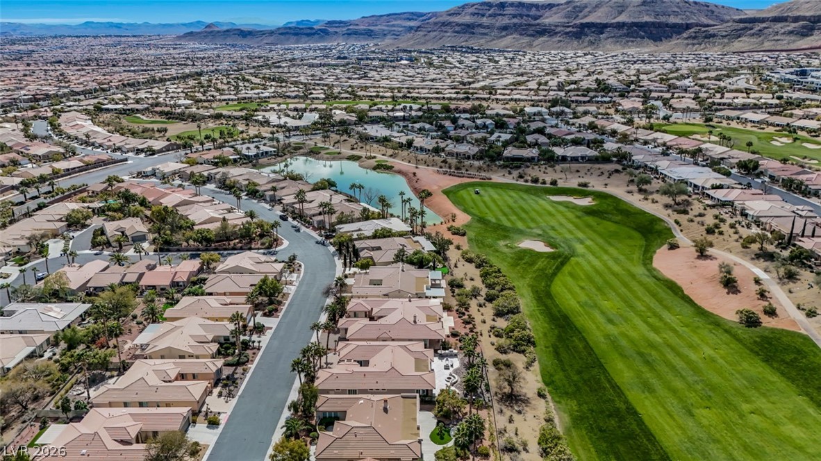 5015 Rivedro Street Las Vegas, NV 89135 - Photo 74 of 91 An aerial panorama reveals a serene residential community nestled beside a lush golf course and tranquil lake.