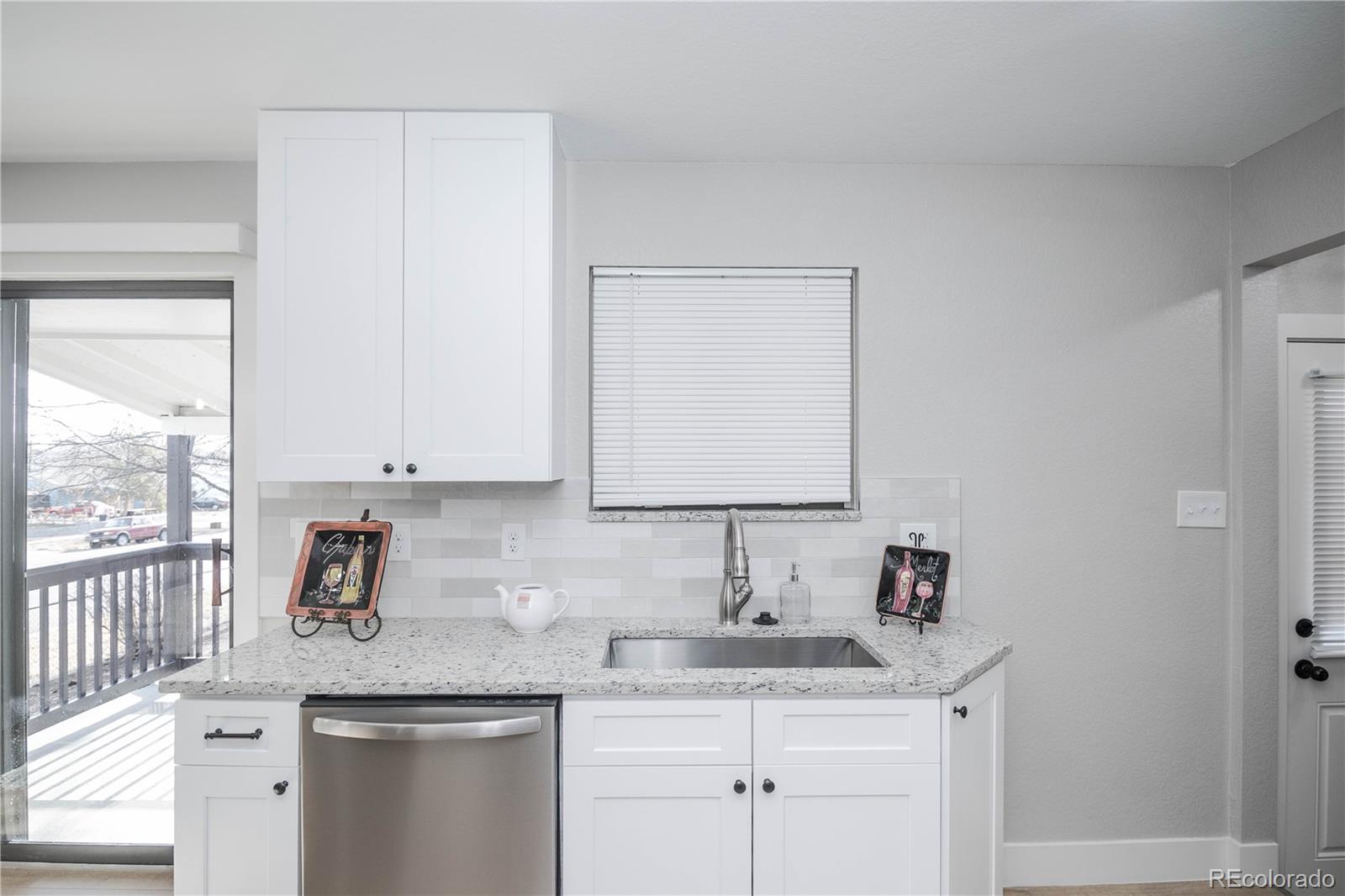820 Drake Street Denver, CO 80221 - Photo 11 of 48 a kitchen with stainless steel appliances granite countertop a sink and a white cabinets