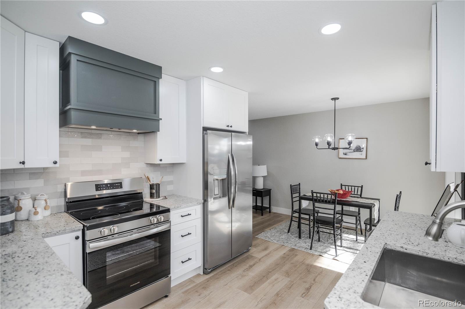 820 Drake Street Denver, CO 80221 - Photo 12 of 48 a kitchen with stainless steel appliances a stove a sink dishwasher a refrigerator and a dining table with wooden floor