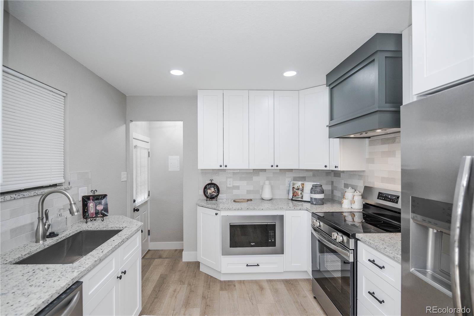 820 Drake Street Denver, CO 80221 - Photo 9 of 48 a kitchen with stainless steel appliances granite countertop a sink stove and refrigerator