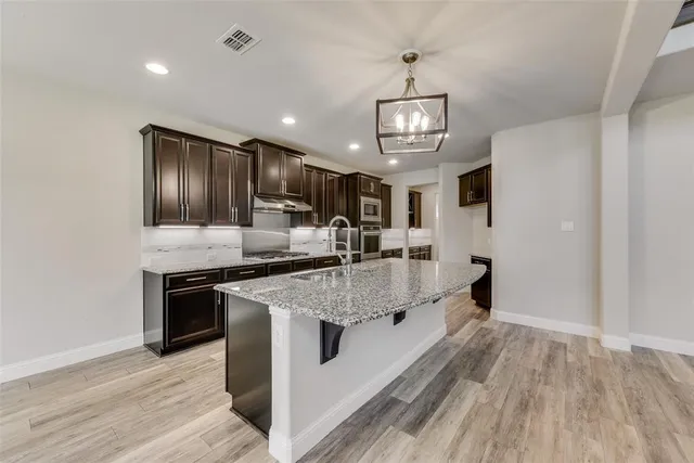 a kitchen with stainless steel appliances granite countertop a sink stove and refrigerator