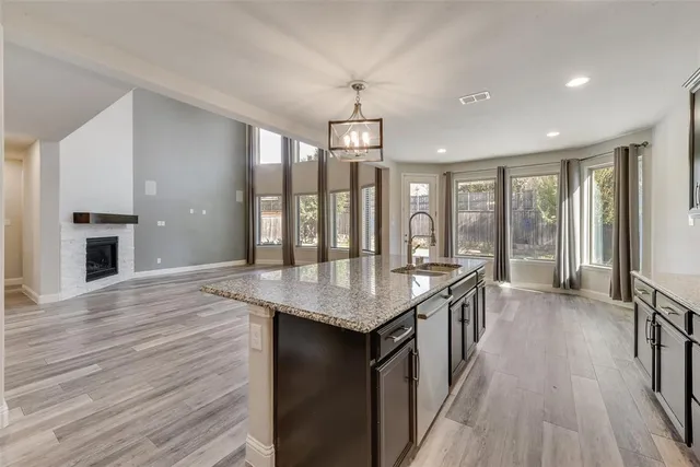 an open kitchen with granite countertop a stove and wooden floor