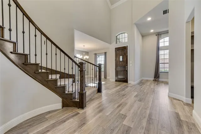 a view of a hallway with wooden floor and staircase