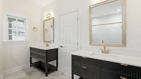 a bathroom with double sink and two mirror