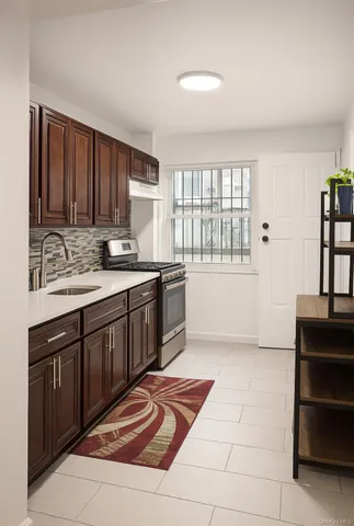 a kitchen with stainless steel appliances granite countertop a stove a sink and a microwave