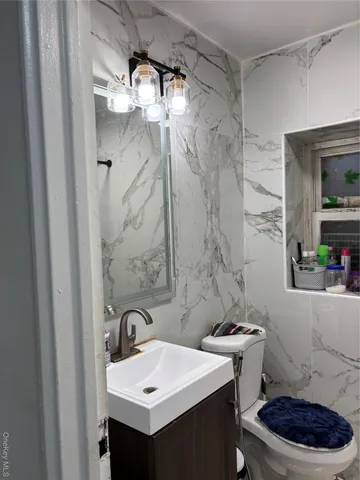 a bathroom with a sink a toilet a mirror and shower