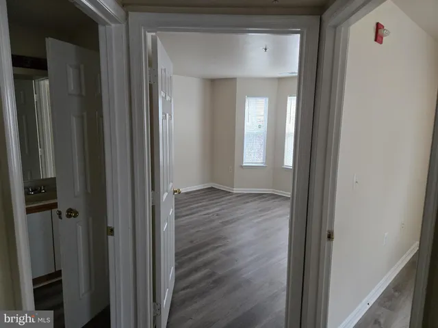 a view of a hallway with wooden floor and closet area