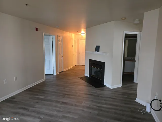 a view of a livingroom with wooden floor and a fireplace